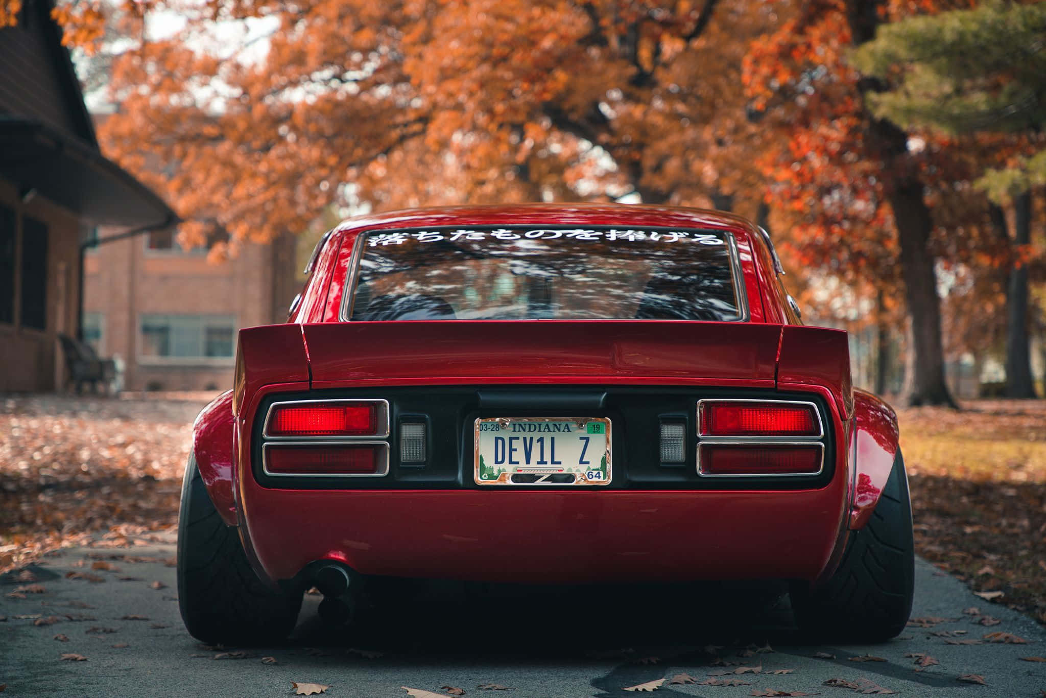 Slank rød Datsun-bil parkeret på en bygade Wallpapers