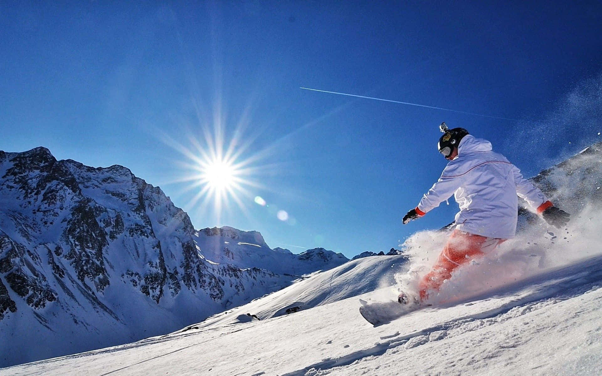 Snowboarder svæver højt over et snedækket bjerg Wallpapers
