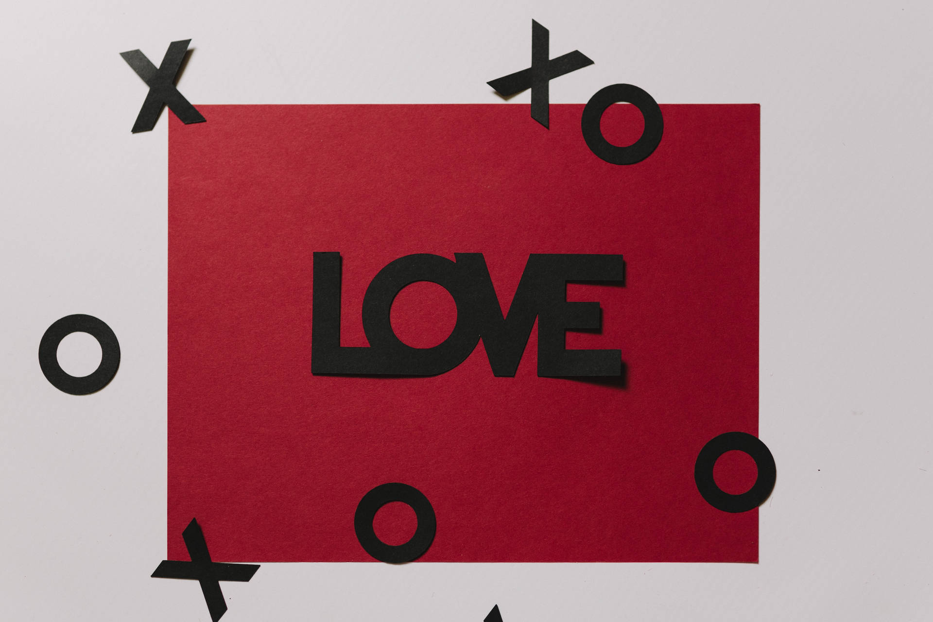 Rødt kærlighedsbrev med påskriften "Love" i sort og flydende udskæringer af XOXO på hvid overflade. — Kærlighed Wallpapers