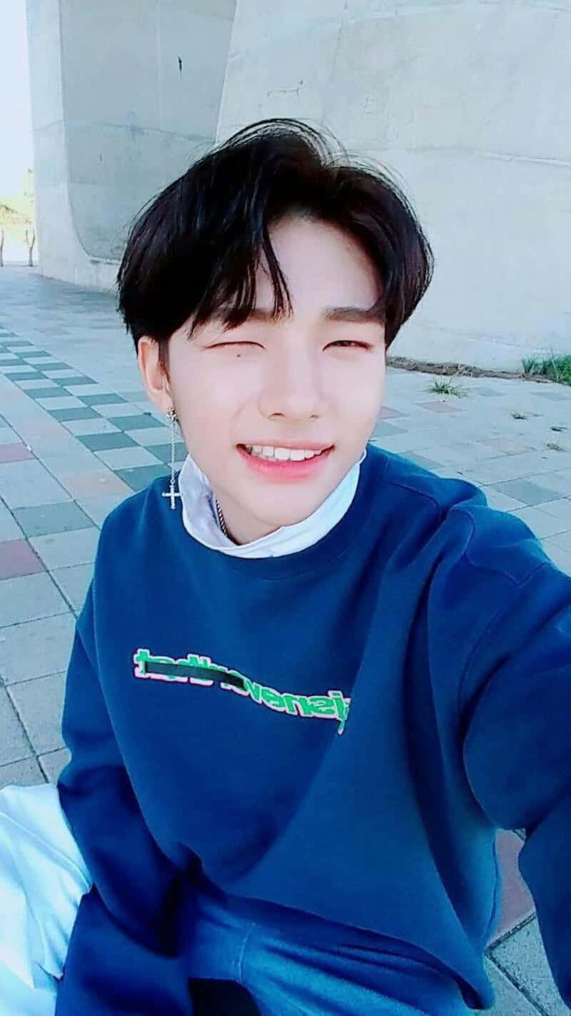 Sydkoreansk rapper Hyunjin, der blinker til et selfie Wallpapers