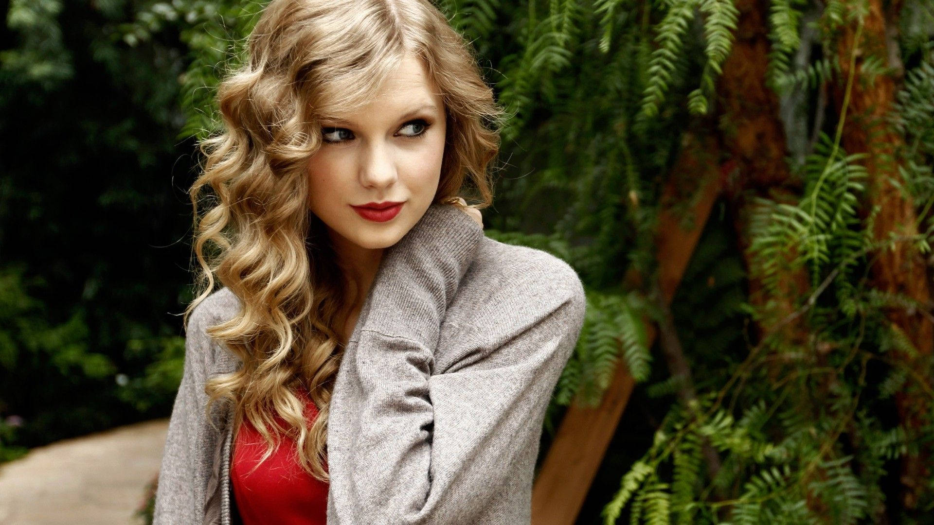 Pæn sød krøllet Taylor Swift sideblik positur wallpaper foto. — Taylor Swift Wallpapers