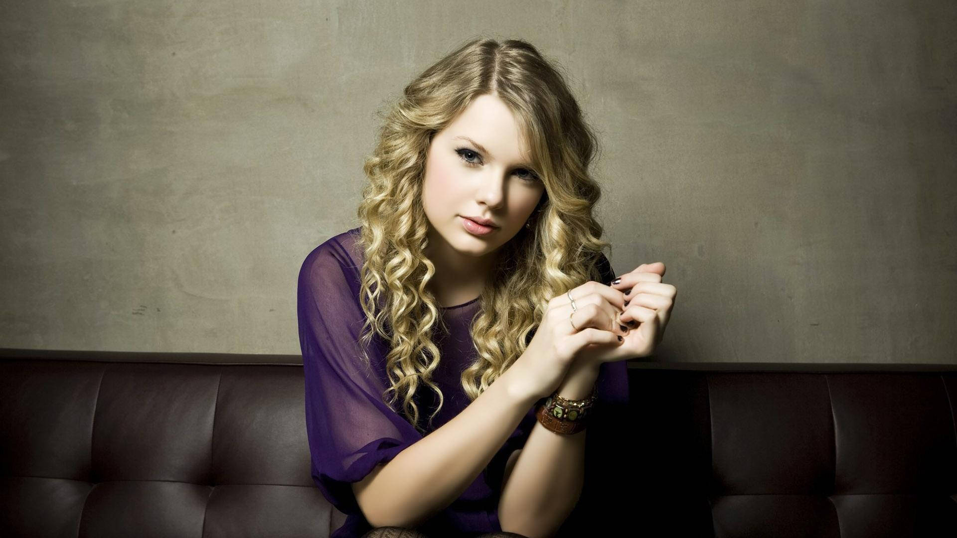 Taylor Swift udstråler positiv energi med sit signaturkrøllede hår. Wallpapers