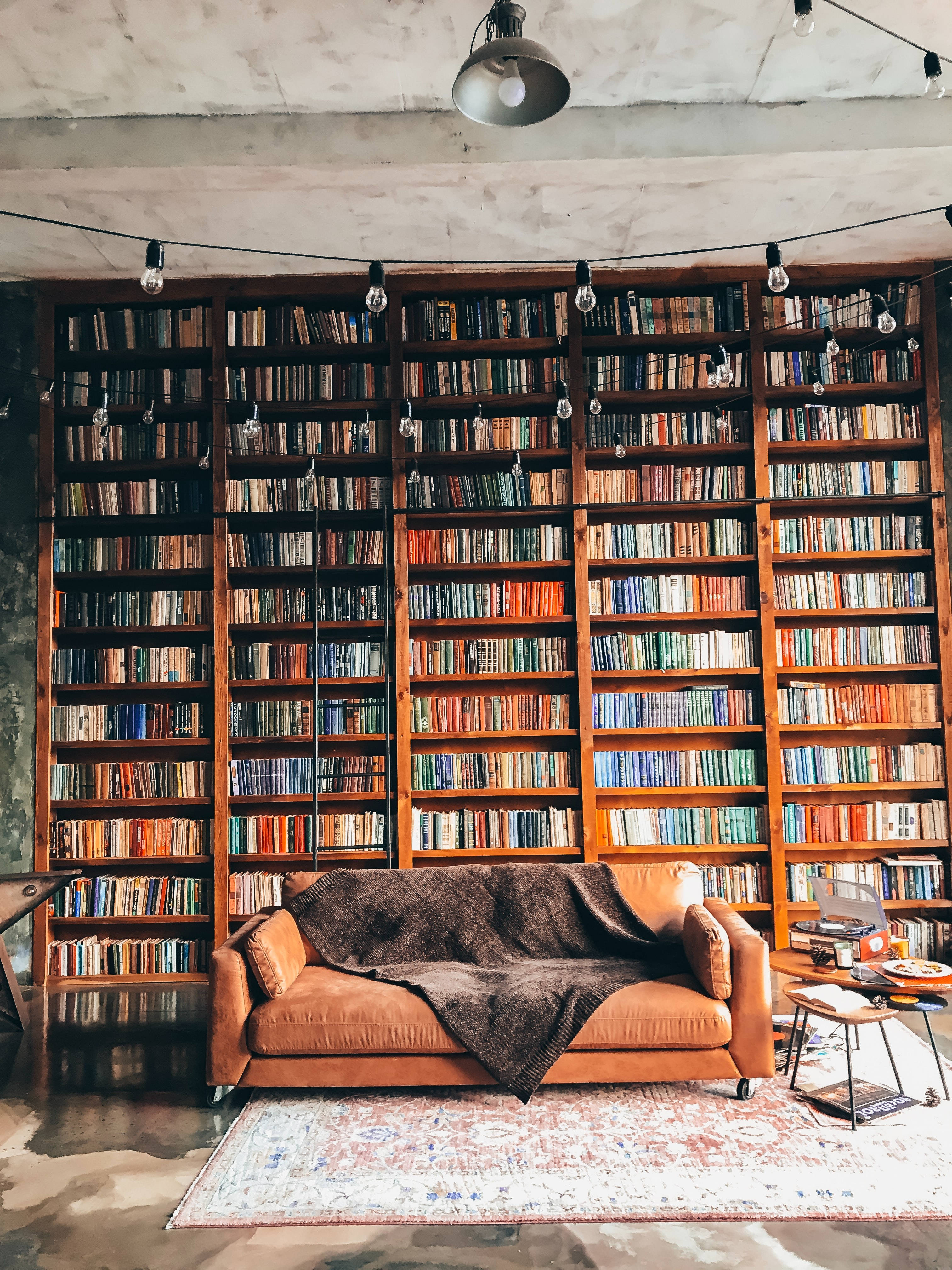 Traditionelt biblioteksinteriør med hyggelig sofa Wallpapers