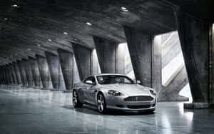 Aston Martin DB9 kører gennem en naturskøn byudsigt — Steam Deck OLED Wallpapers