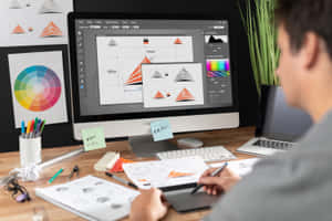 En mand arbejder på en computer med en masse papir — Grafisk design Wallpapers