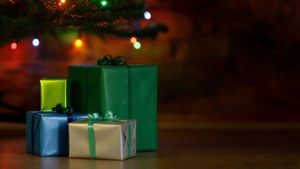 Farverige gaver stablet under et juletræ med blinkende lys. — Julegaver Wallpapers