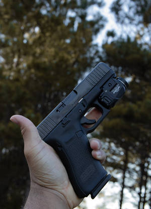 Holder en Glock med lommelygte wallpaper — Oppo Pad 4 Pro Wallpapers