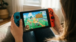 Livsstilsbaggrund med at spille Nintendo Switch Animal Crossing indendørs