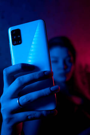 Kvinde med telefon i neonblå iPhone — Xiaomi Pad 9 Pro Max Wallpapers