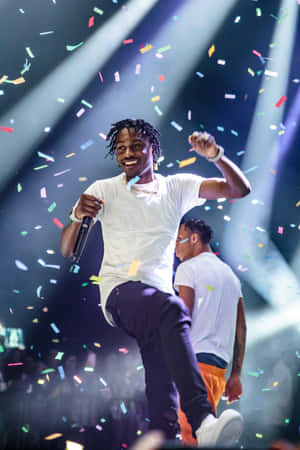 Lil Tjay poserer i stilfuldt urbant outfit i et svagt oplyst miljø — Vivo Pad SE Wallpapers