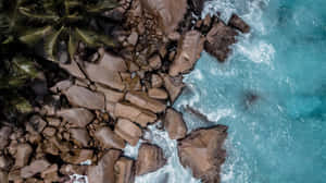 Luftfoto af klippeformationer ved stranden med bølger — Hav Wallpapers