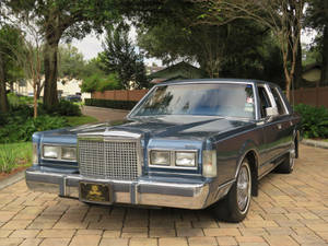 Majestætisk 1986 Lincoln Town Car parkeret på en asfalteret indkørsel — Seje biler GIF Wallpapers