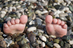 Fødder på klipper under sommerferie, sjov situation på stranden med småsten. — Sommer Wallpapers